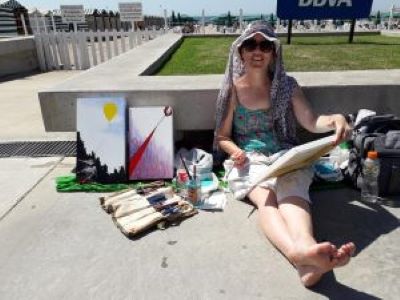 Foto de la artista pintando en una playa